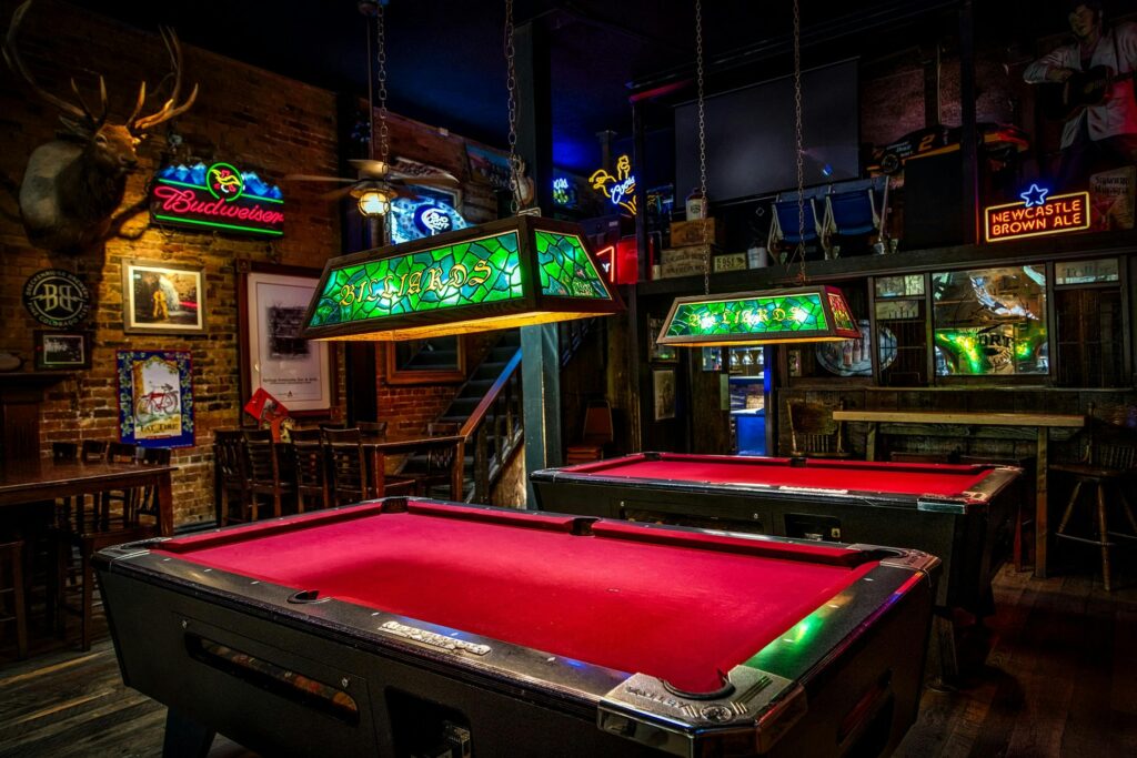 Atmospheric bar with neon lights and billiard tables. Cozy and vibrant setting.